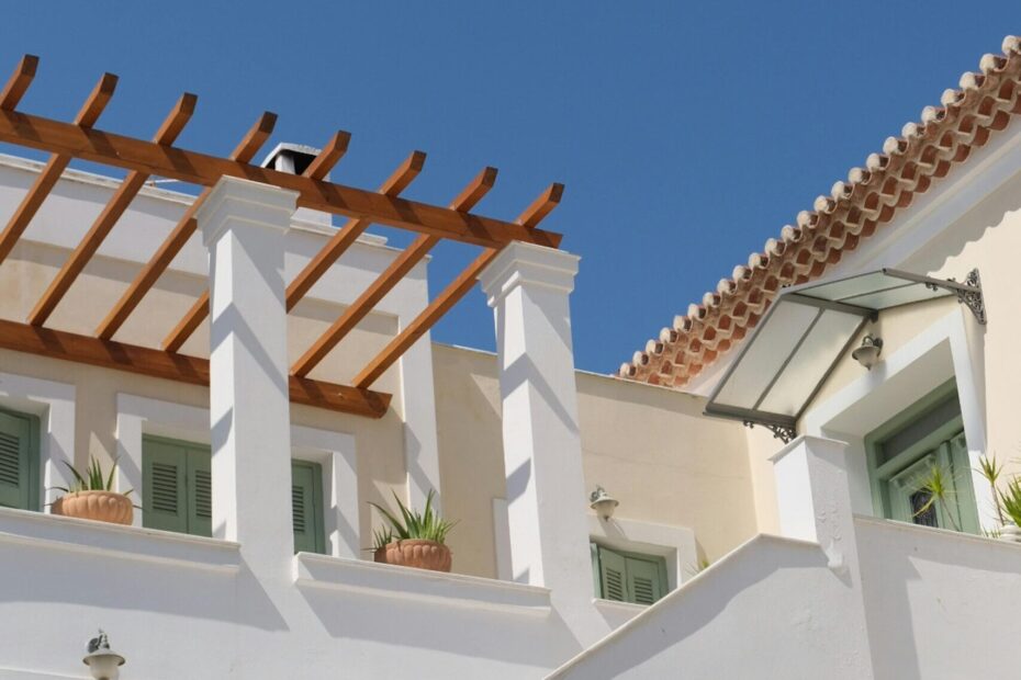 Elegant Mediterranean house exterior with white walls under a clear blue sky.